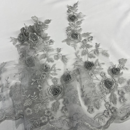 Silver floral embroidered lace trim featuring 3D rose appliqués, metallic thread embroidery, and a scalloped edge ,  on a white background