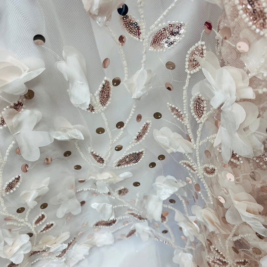 Close-up of a white embroidered fabric with 3D floral appliqué, bead vines and  sequins- Lace USA  