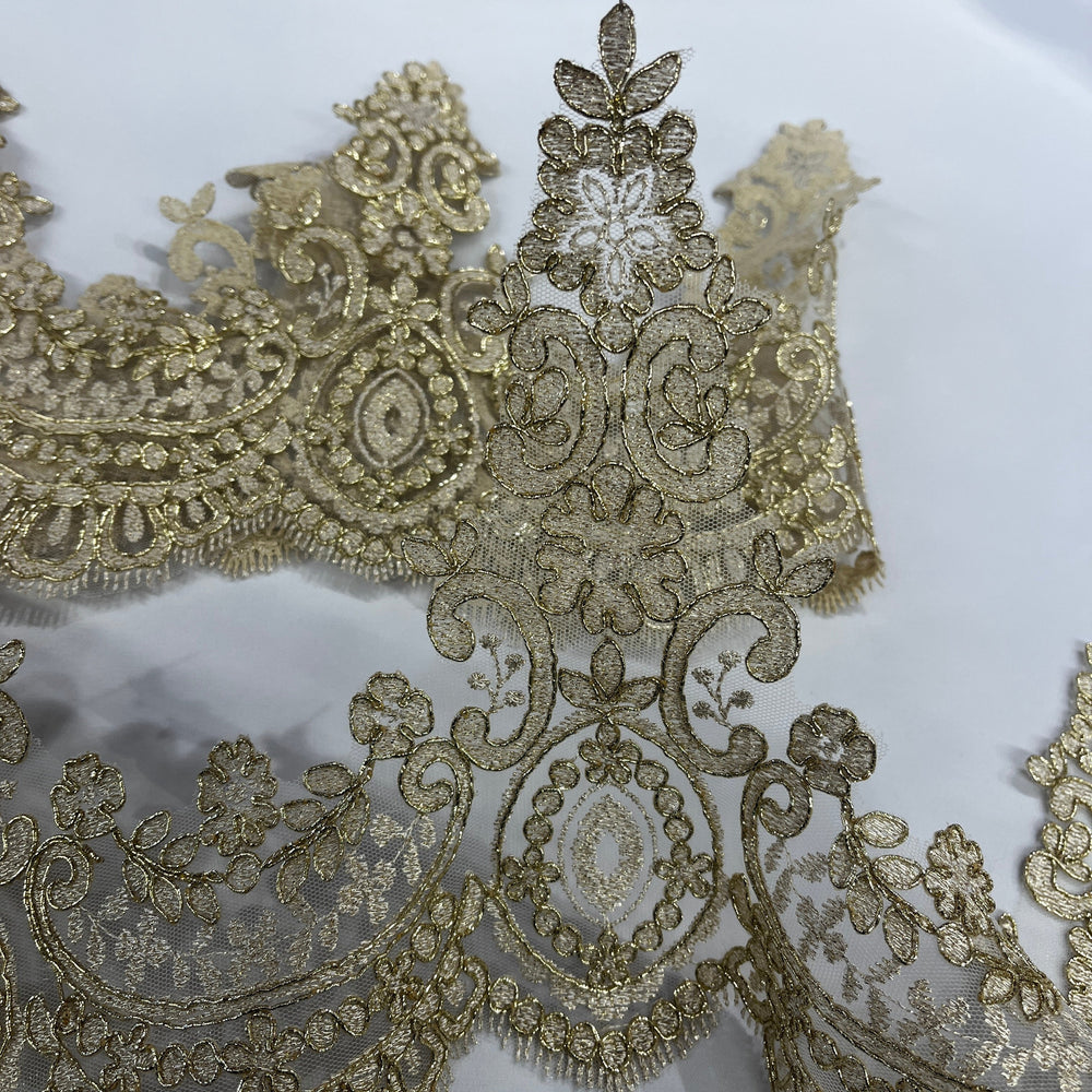 Close-up of 9-inch antique gold corded floral lace trim with ornate embroidery and scalloped edging on a white background, Lace USA 96794W. 