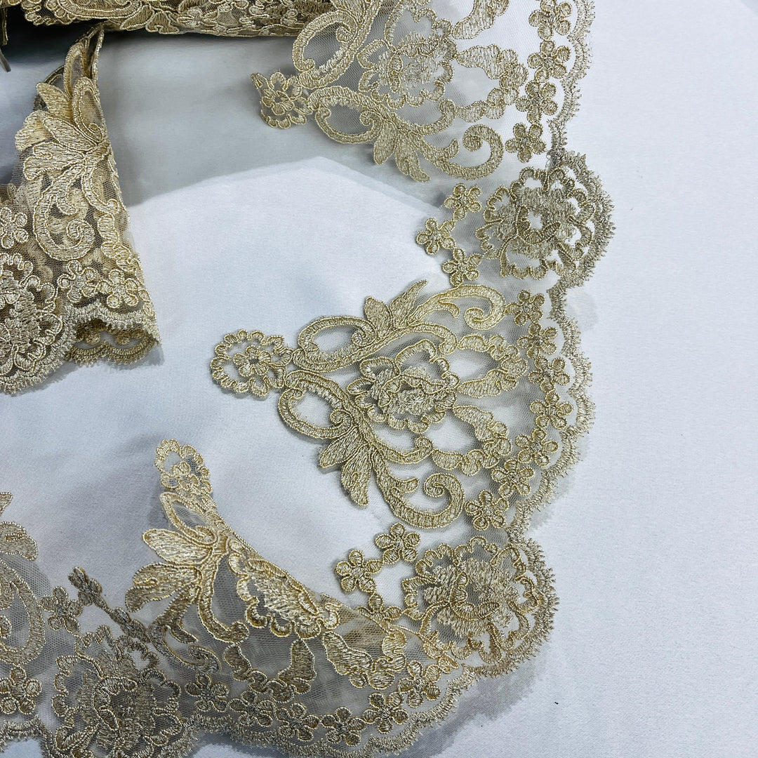 Closeup of Ornate Antique gold embroidered lace trim with delicate cording, symmetrical floral patterns, and fine detailing | Lace USA - 97214W