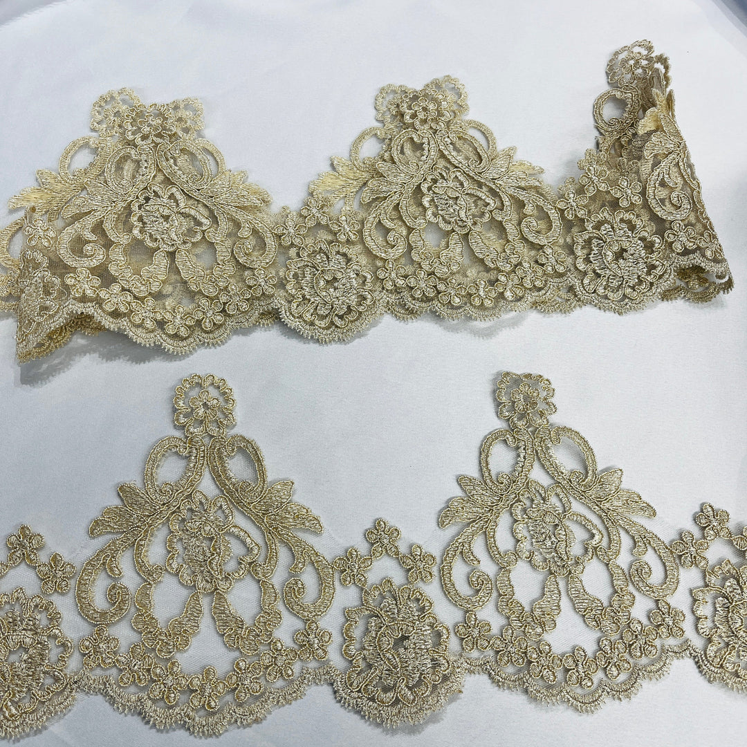 Gold embroidered lace trim with intricate floral and paisley motifs defined by delicate cordingon white fabricLace USA - 97214W