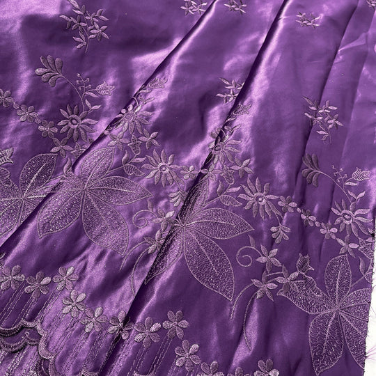 Plum silk fabric with silver floral and leaf embroidery, draped to show its sheen and texture.