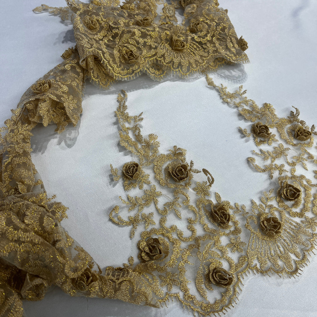 Gold floral lace fabric with embroidered 3D rose motifs and net mesh, laid out on a white background. Lace USA #21856W
