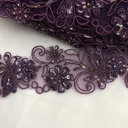 Closeup of a Plum lace trim with floral and leaf patterns |LaceUSA 96283N-BP