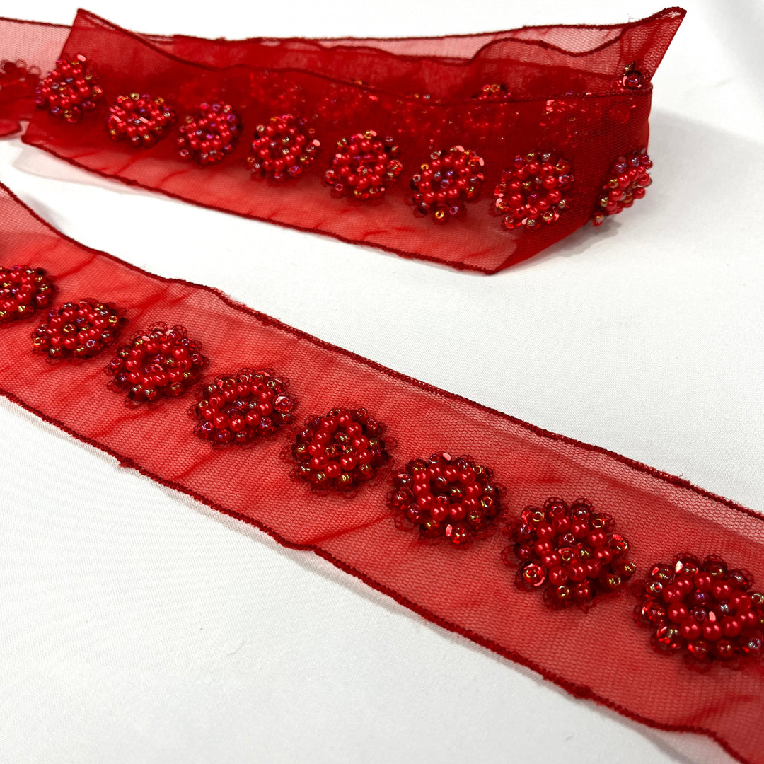 Red sheer net mesh trim ribbon with beaded & sequined  floral patterns, shown coiled and laid flat on a white background. Lace USA  #21766WNBP 