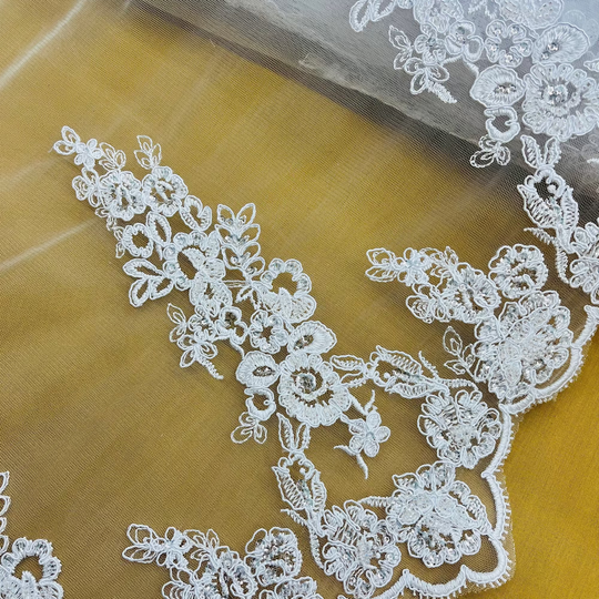 Closeup of white Beaded & Corded Bridal Lace Fabric Embroidered on 100% Polyester Net Mesh | Lace USA